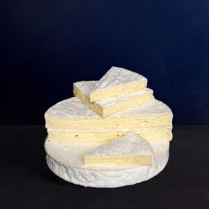 Stacked slices of brie cheese on dark background