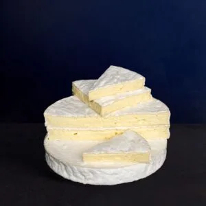 Stacked Brie cheese wedges on dark background