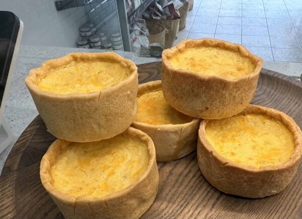 Freshly baked individual cheese quiches in a bakery