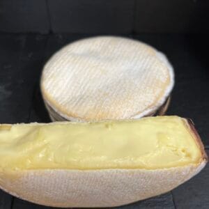 Whole and sliced wheel of creamy cheese
