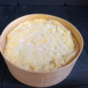 Creamy mashed potatoes in wooden bowl on slate surface