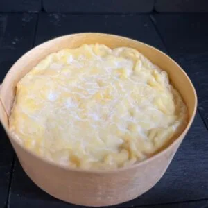 Creamy mashed potatoes in wooden bowl on slate surface