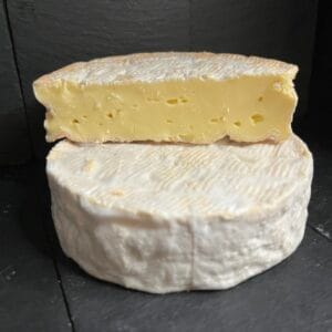 Sliced soft cheese on dark slate background