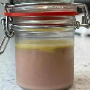 Layered dessert in a sealed glass jar on counter