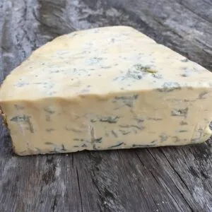 Wedge of blue cheese on rustic wooden surface