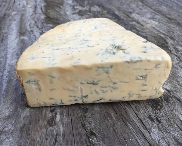 Wedge of blue cheese on rustic wooden surface