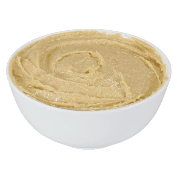 Bowl of smooth, creamy hummus on green background