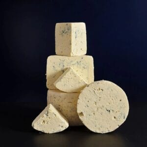 Stack of blue cheese blocks on dark background