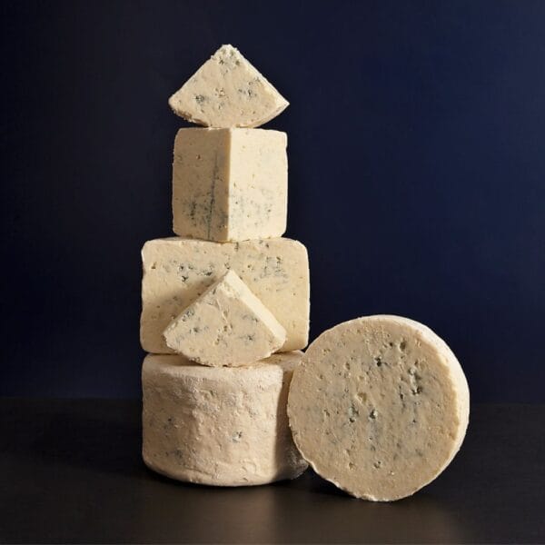 Stacked various blue cheeses on dark background