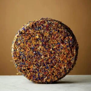 Colourful dried flower-covered sphere on beige background