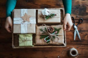 Person holding tray of rustic handmade Christmas gifts