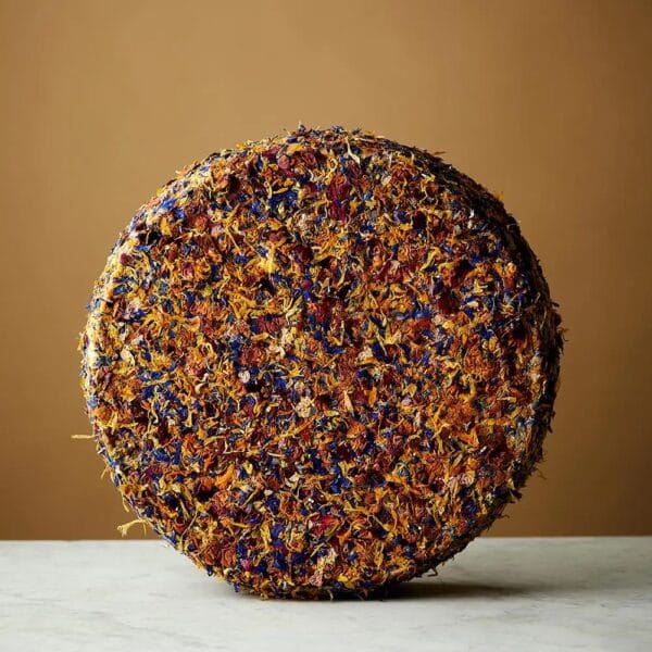 Colourful dried flower-covered spherical object on table