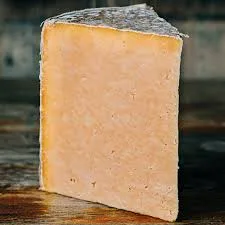 Aged cheddar cheese on wooden surface