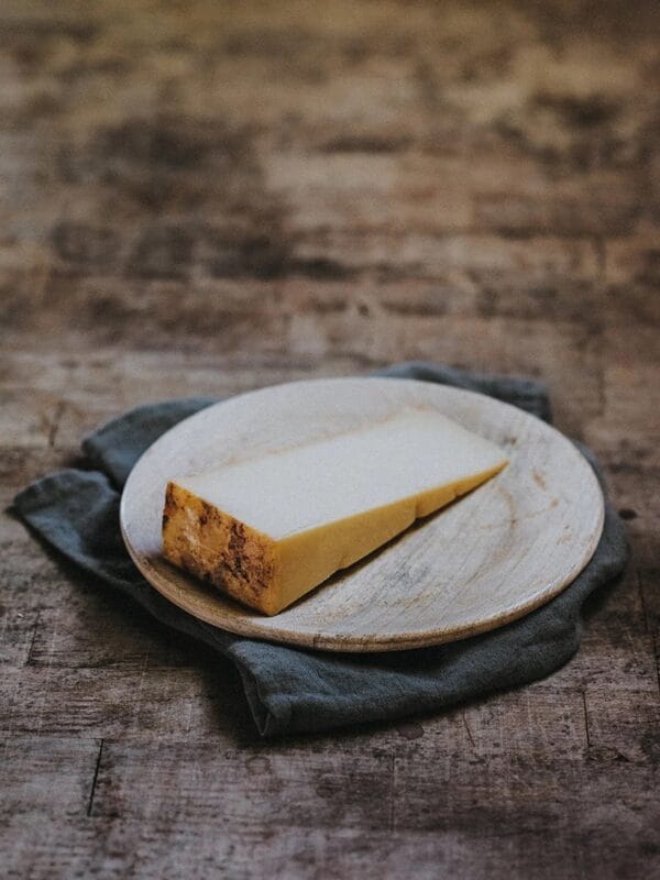 Slice of rustic homemade cheesecake on wooden plate