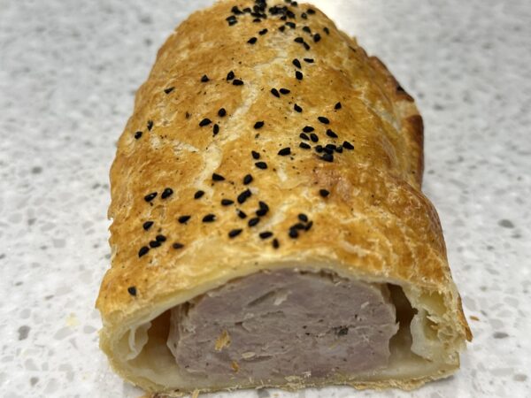 Close-up of sliced sausage roll with black sesame seeds