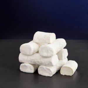 Stack of soft white goat cheese logs on table