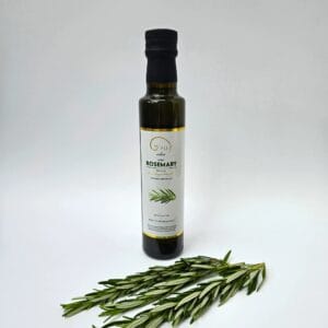 Rosemary oil bottle next to fresh rosemary sprigs