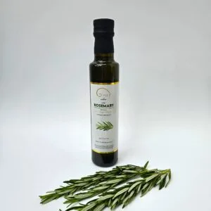Rosemary oil bottle next to fresh rosemary sprigs