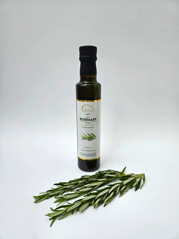 Rosemary oil bottle next to fresh rosemary sprigs