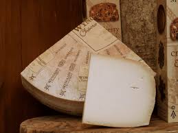 Vintage cheese wheel beside wine label