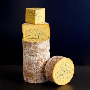 Stacked blue cheeses on dark background