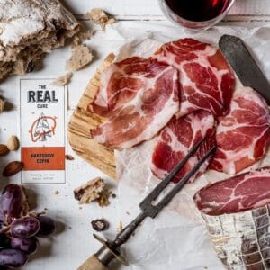 Artisan cured meats, bread, grapes, and almonds on table