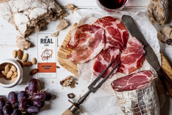Artisan cured meats, bread, grapes, and almonds on table