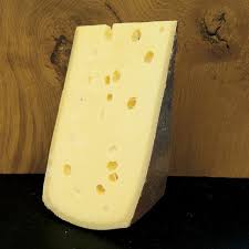 Wedge of Swiss cheese on wooden background