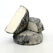 Sliced ash-coated artisan cheese on white background