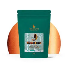 Green coffee packet beside orange fruit
