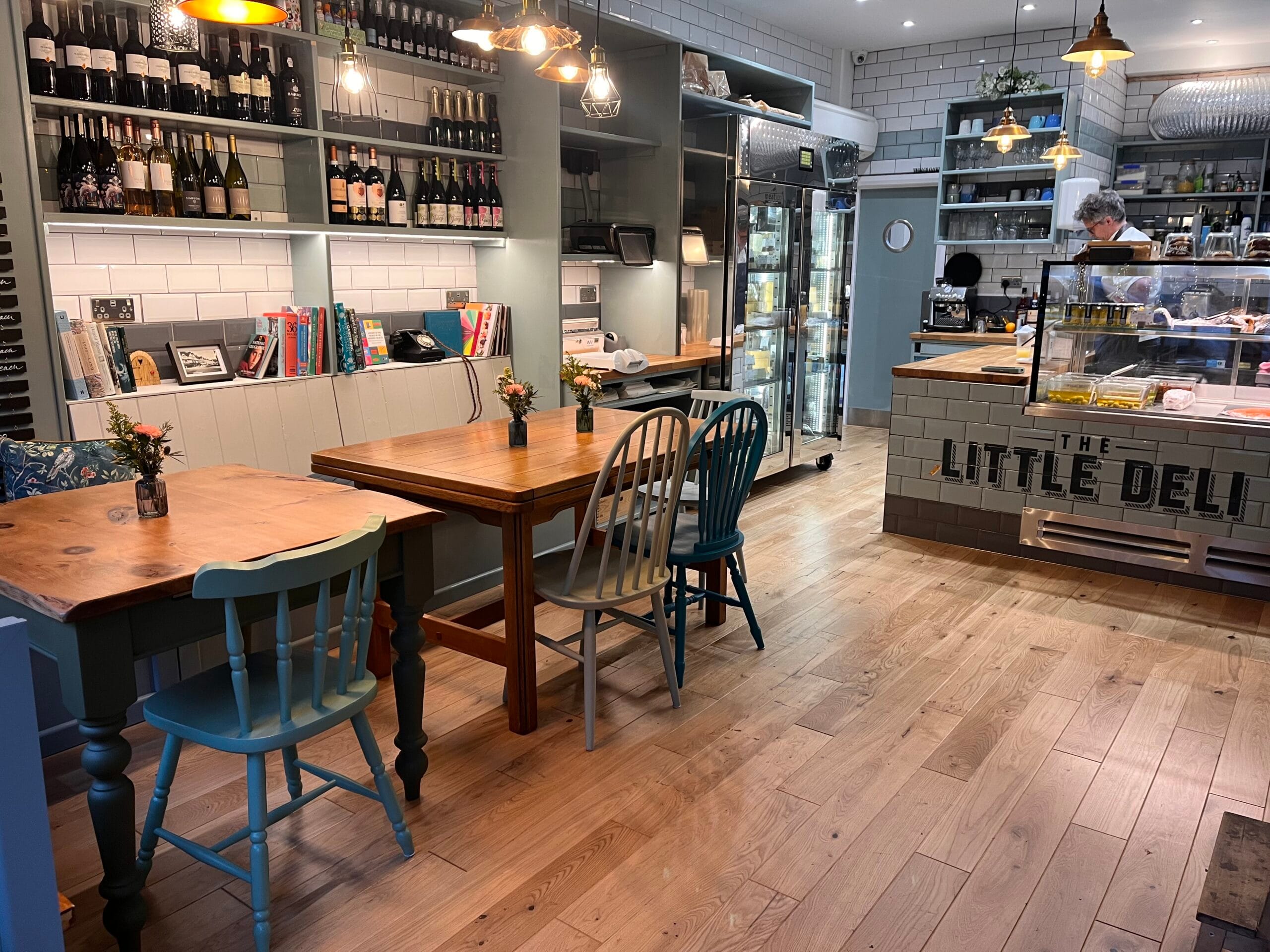 The Little Deli in hitchin, tiled county with fresh foods, and person serving.