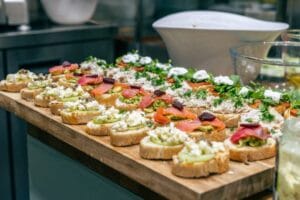 Assorted open sandwiches on a wooden serving board